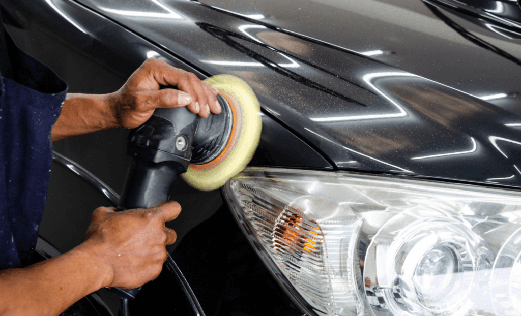 Buffing out a scratch on a car, showing the importance of car care in the new year.