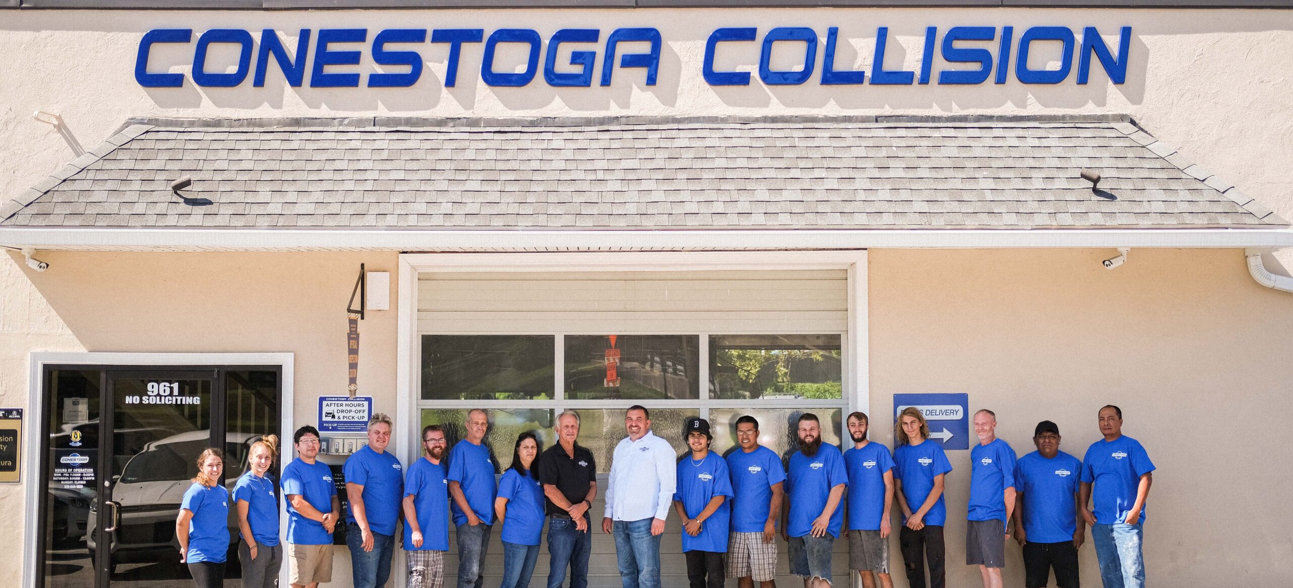 Owners Max Keller and Pete Hutchinson stand with 15 team members outside the front of Conestoga Collision